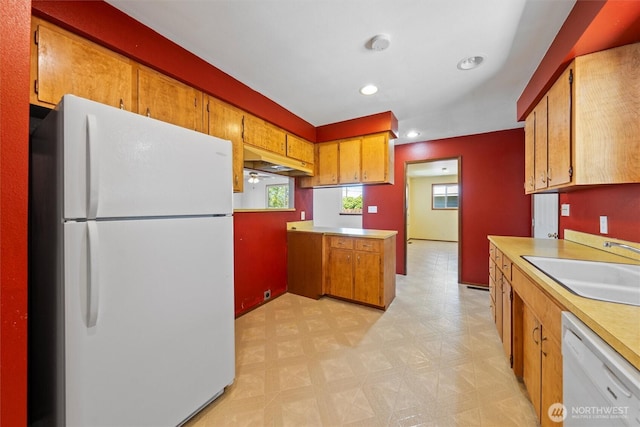 103 Crest Dr, Ephrata, WA 98823 - kitchen with white appliances, light flooring, light countertops, brown cabinets, and a peninsula