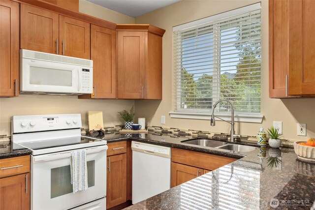 6125 Kennedy Ave SE Unit F7, Auburn, WA 98092 - kitchen with white appliances, healthy amount of natural light, brown cabinetry, and dark stone counters