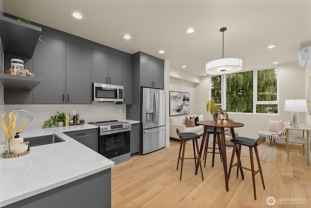 1106C 34th Ave, Seattle, WA 98122 - kitchen featuring stainless steel appliances, open shelves, light countertops, backsplash, and light wood-style floors