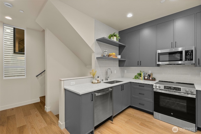 1106C 34th Ave, Seattle, WA 98122 - kitchen featuring appliances with stainless steel finishes, gray cabinetry, open shelves, light wood-style floors, and light countertops