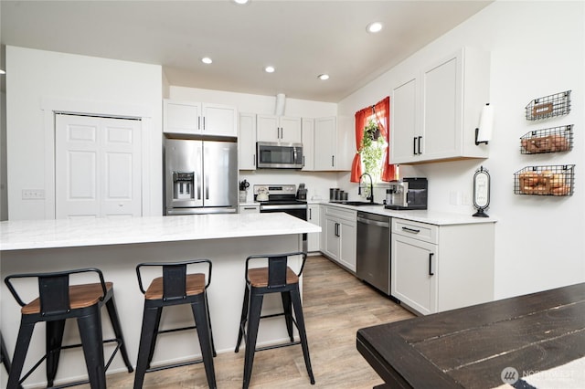 235 Morton St, Sumas, WA 98295 - kitchen featuring stainless steel appliances, a breakfast bar area, recessed lighting, light countertops, and light wood-type flooring