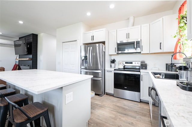 235 Morton St, Sumas, WA 98295 - kitchen featuring stainless steel appliances, a breakfast bar, light stone counters, white cabinets, and recessed lighting