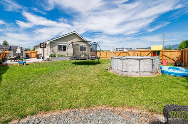 235 Morton St, Sumas, WA 98295 - rear view of house with a trampoline, a fenced backyard, and a patio area