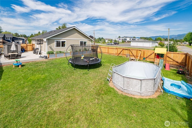 235 Morton St, Sumas, WA 98295 - fenced backyard with a trampoline, an outdoor pool, and a patio