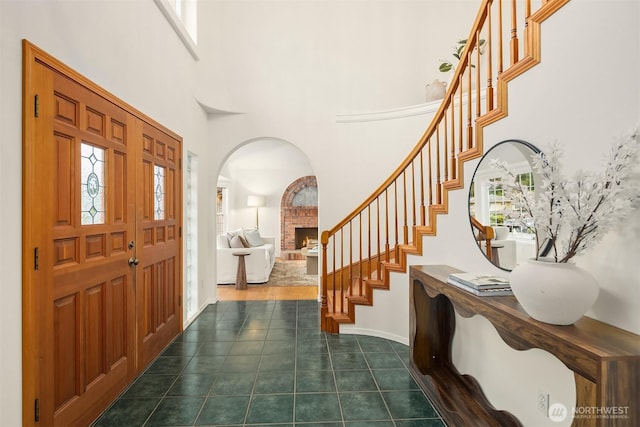 1417 232nd Pl SW, Bothell, WA 98021 - entrance foyer with a towering ceiling, stairs, a fireplace, dark tile patterned flooring, and arched walkways