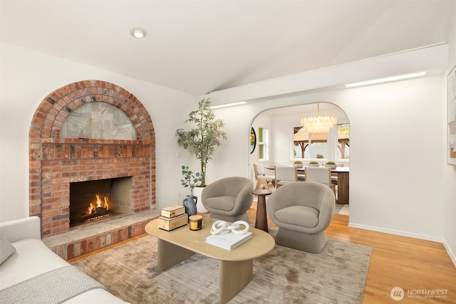 1417 232nd Pl SW, Bothell, WA 98021 - living room featuring wood finished floors, vaulted ceiling, a fireplace, and a chandelier