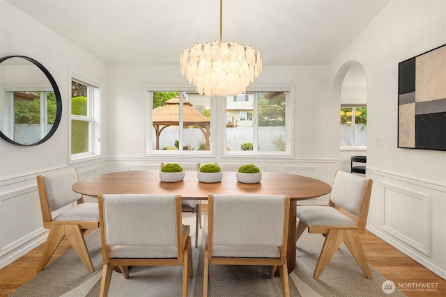 1417 232nd Pl SW, Bothell, WA 98021 - dining area with light wood finished floors, a chandelier, a wainscoted wall, and a decorative wall