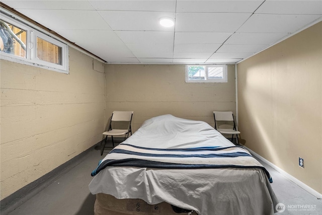 4840 E B St, Tacoma, WA 98404 - bedroom featuring concrete floors, concrete block wall, and a drop ceiling