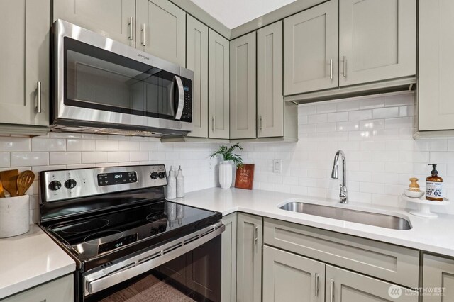 3923 NE 22nd Pl, Renton, WA 98056 - kitchen with appliances with stainless steel finishes, gray cabinets, light countertops, and tasteful backsplash