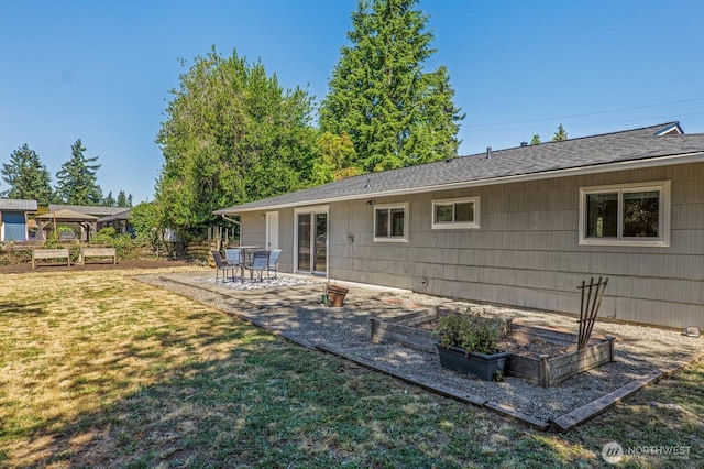 3923 NE 22nd Pl, Renton, WA 98056 - back of house with a yard, a vegetable garden, a patio, and a shingled roof