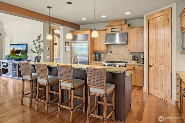 80 Queens Loop, Cle Elum, WA 98922 - kitchen with appliances with stainless steel finishes, wall chimney range hood, light wood-style flooring, tasteful backsplash, and recessed lighting