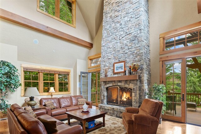 80 Queens Loop, Cle Elum, WA 98922 - living area featuring high vaulted ceiling, wood finished floors, a fireplace, and healthy amount of natural light