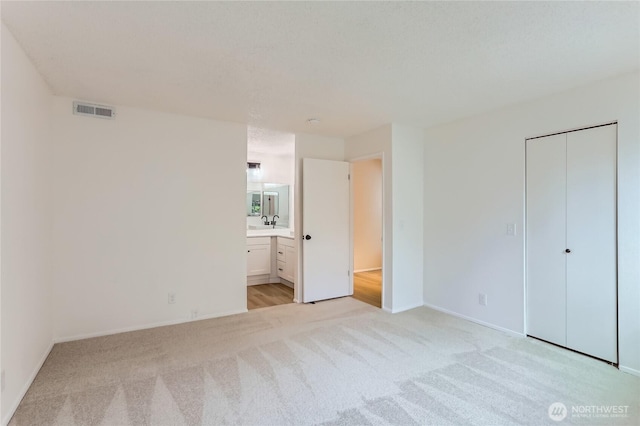 7435 Old Redmond Rd Unit 325, Redmond, WA 98052 - unfurnished bedroom featuring light carpet, ensuite bathroom, and a closet
