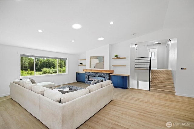 2403 E Hemmi Rd, Bellingham, WA 98226 - living room featuring lofted ceiling, light wood finished floors, stairway, a fireplace, and recessed lighting
