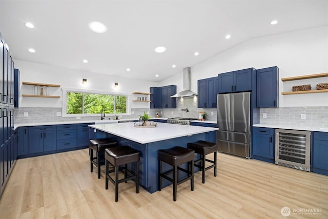 2403 E Hemmi Rd, Bellingham, WA 98226 - kitchen featuring open shelves, stainless steel appliances, wall chimney exhaust hood, beverage cooler, and a kitchen bar