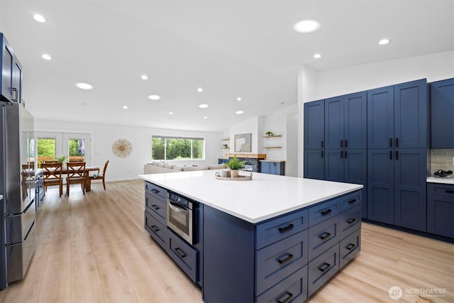 2403 E Hemmi Rd, Bellingham, WA 98226 - kitchen with freestanding refrigerator, light wood-style floors, recessed lighting, blue cabinets, and light countertops