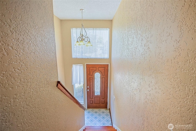 5428 172nd St SW, Lynnwood, WA 98037 - entrance foyer featuring a chandelier, a textured wall, a textured ceiling, and wood finished floors
