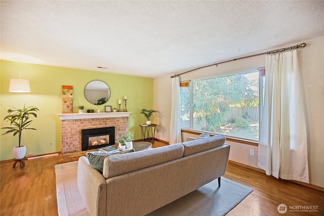 5428 172nd St SW, Lynnwood, WA 98037 - living room featuring a textured ceiling, a fireplace, and wood finished floors