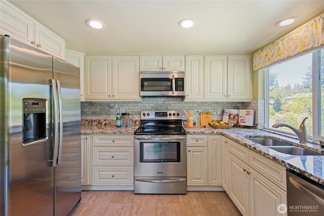 5428 172nd St SW, Lynnwood, WA 98037 - kitchen featuring appliances with stainless steel finishes, light stone counters, decorative backsplash, light wood finished floors, and recessed lighting