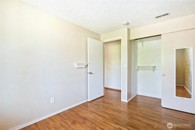 5428 172nd St SW, Lynnwood, WA 98037 - unfurnished bedroom with a closet, wood finished floors, and a textured ceiling