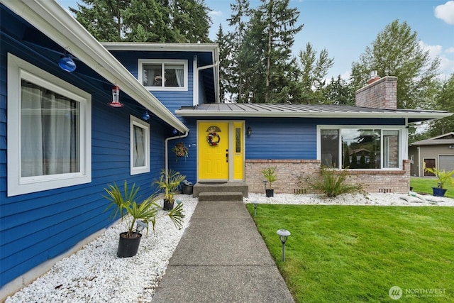 5502 82nd Street Ct E, Puyallup, WA 98371 - view of front of house with a front yard, brick siding, a chimney, a standing seam roof, and a metal roof