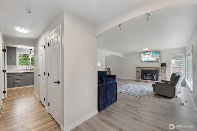 5502 82nd Street Ct E, Puyallup, WA 98371 - living area featuring a fireplace, light wood-type flooring, healthy amount of natural light, and arched walkways