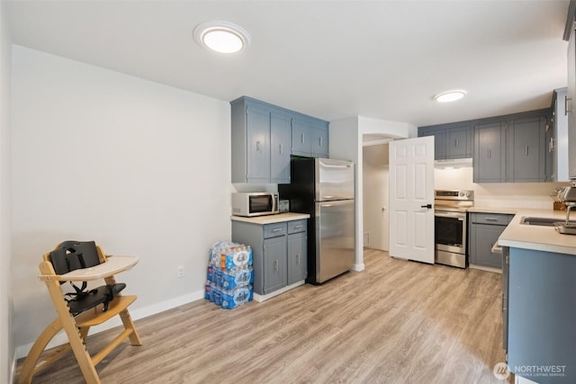 5502 82nd Street Ct E, Puyallup, WA 98371 - kitchen featuring stainless steel appliances, light wood-style flooring, light countertops, and under cabinet range hood