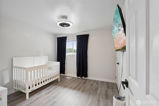 5502 82nd Street Ct E, Puyallup, WA 98371 - bedroom featuring wood finished floors and a crib