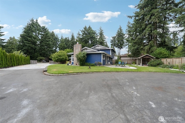 5502 82nd Street Ct E, Puyallup, WA 98371 - view of front of house featuring a chimney, a patio, and driveway