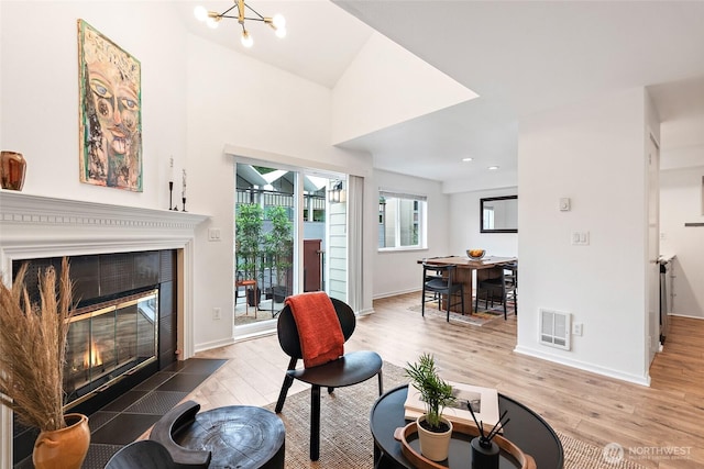 1926 Fairview Ave E Unit 307, Seattle, WA 98102 - living area featuring a tiled fireplace, wood finished floors, a chandelier, and recessed lighting