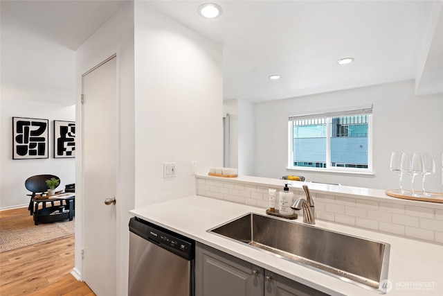 1926 Fairview Ave E Unit 307, Seattle, WA 98102 - kitchen with stainless steel dishwasher, light countertops, light wood-style flooring, decorative backsplash, and recessed lighting