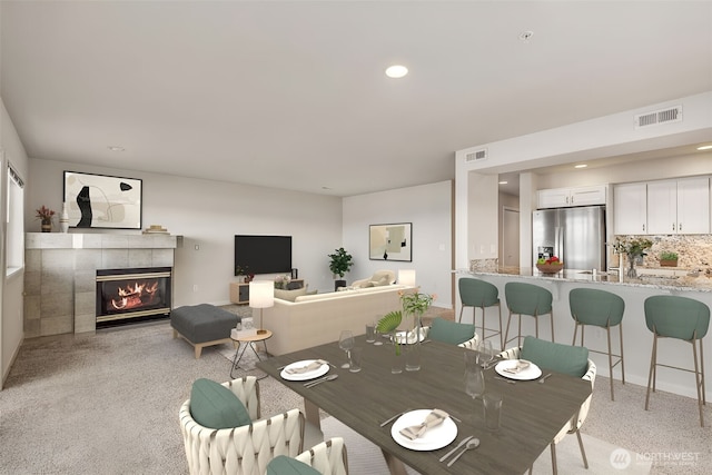 1300 Alki Ave SW Unit 100, Seattle, WA 98116 - dining space featuring light carpet, a tiled fireplace, and recessed lighting
