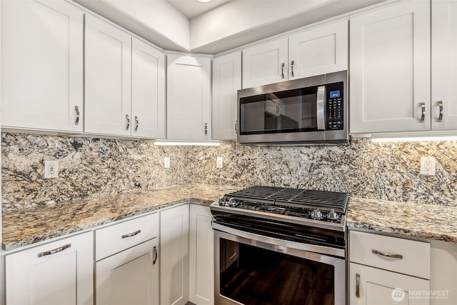 1300 Alki Ave SW Unit 100, Seattle, WA 98116 - kitchen with stainless steel appliances, white cabinets, and tasteful backsplash