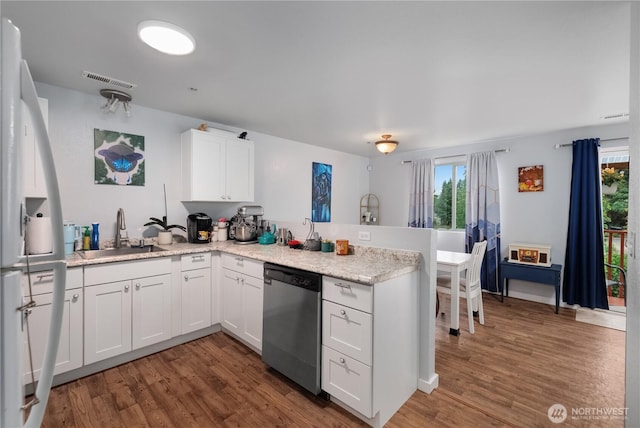 1222 Cora St SE, Lacey, WA 98503 - kitchen featuring stainless steel dishwasher, a peninsula, wood finished floors, white cabinets, and freestanding refrigerator