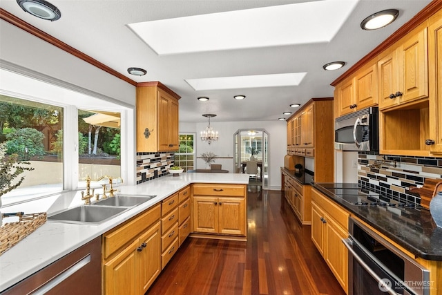 3322 Pacific Way, Longview, WA 98632 - kitchen featuring stainless steel appliances, a skylight, a peninsula, dark wood-style flooring, and backsplash