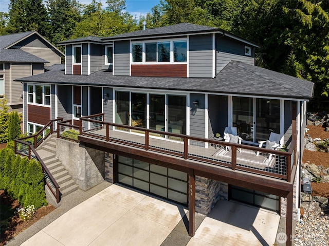 921 Whitewater Dr, Bellingham, WA 98229 - rear view of house featuring an attached garage, a shingled roof, driveway, stone siding, and stairs