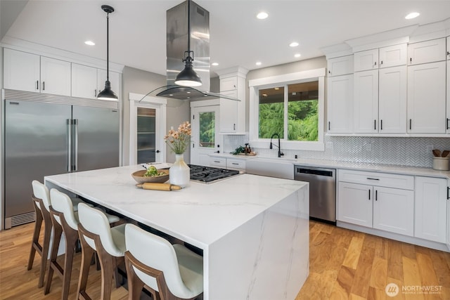 921 Whitewater Dr, Bellingham, WA 98229 - kitchen with appliances with stainless steel finishes, island range hood, white cabinets, decorative backsplash, and recessed lighting