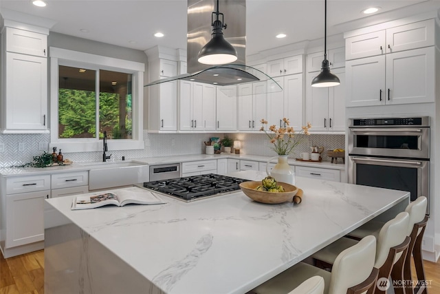 921 Whitewater Dr, Bellingham, WA 98229 - kitchen featuring island exhaust hood, stainless steel appliances, white cabinetry, a center island, and recessed lighting