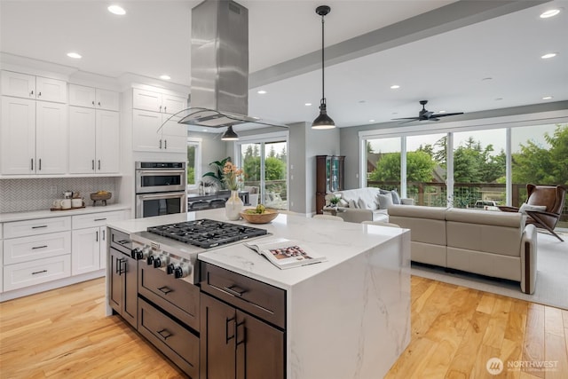 921 Whitewater Dr, Bellingham, WA 98229 - kitchen featuring appliances with stainless steel finishes, island exhaust hood, open floor plan, white cabinetry, and recessed lighting