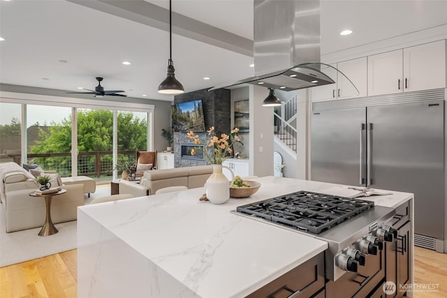 921 Whitewater Dr, Bellingham, WA 98229 - kitchen with stainless steel appliances, island range hood, open floor plan, white cabinetry, and a ceiling fan