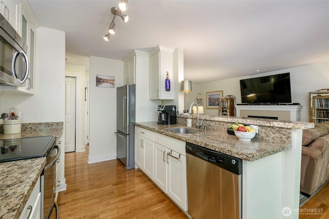 22910 90th Ave W Unit C103, Edmonds, WA 98026 - kitchen with appliances with stainless steel finishes, a peninsula, white cabinets, open floor plan, and light wood finished floors