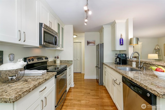 22910 90th Ave W Unit C103, Edmonds, WA 98026 - kitchen with appliances with stainless steel finishes, white cabinetry, light wood finished floors, and light stone counters