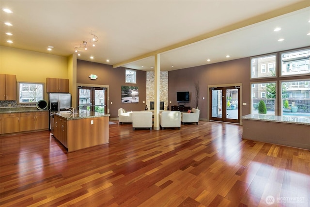 22910 90th Ave W Unit C103, Edmonds, WA 98026 - kitchen with french doors, open floor plan, brown cabinets, recessed lighting, and dark wood finished floors
