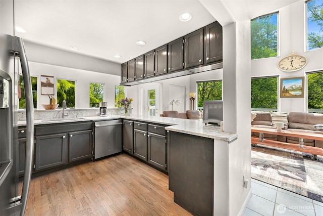8894 Giles Rd, Blaine, WA 98230 - kitchen with stainless steel appliances, light stone counters, recessed lighting, open floor plan, and light wood-type flooring