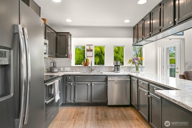 8894 Giles Rd, Blaine, WA 98230 - kitchen with stainless steel appliances, plenty of natural light, light stone countertops, light wood-style flooring, and recessed lighting
