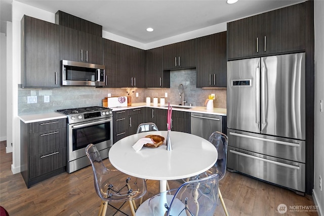 1706 Alki Ave SW Unit A, Seattle, WA 98116 - kitchen with appliances with stainless steel finishes, light countertops, dark wood-type flooring, recessed lighting, and decorative backsplash
