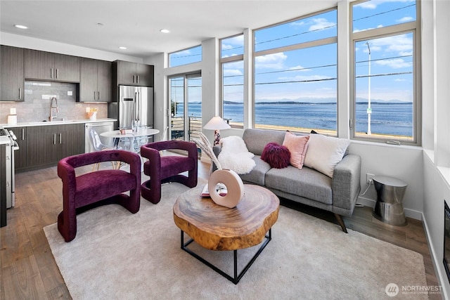 1706 Alki Ave SW Unit A, Seattle, WA 98116 - living room with light wood finished floors, a water view, and recessed lighting