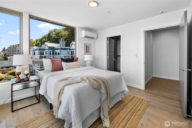 1706 Alki Ave SW Unit A, Seattle, WA 98116 - bedroom featuring a wall unit AC and light wood finished floors