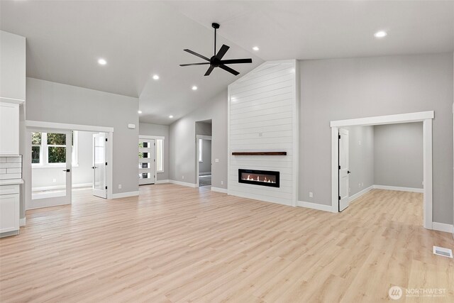 821 174th Ave NW, Lakebay, WA 98349 - unfurnished living room featuring a ceiling fan, light wood-style flooring, a large fireplace, recessed lighting, and high vaulted ceiling