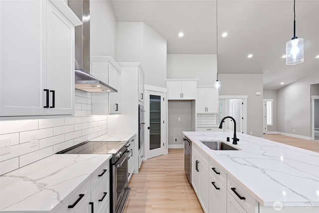 821 174th Ave NW, Lakebay, WA 98349 - kitchen with wall chimney range hood, appliances with stainless steel finishes, light wood-style floors, a kitchen island with sink, and recessed lighting